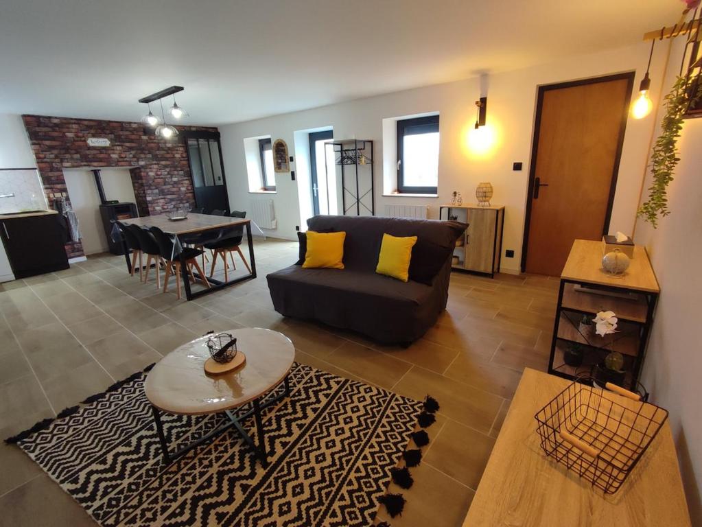 un salon avec un canapé et une table dans l'établissement Gîte L'Ermitage des Pré'O, à Neuvy-Grandchamp