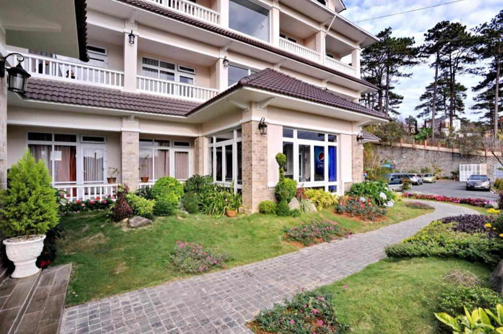 une maison avec un jardin devant dans l'établissement Nhat Vy Hotel, à Ấp Ða Lợi