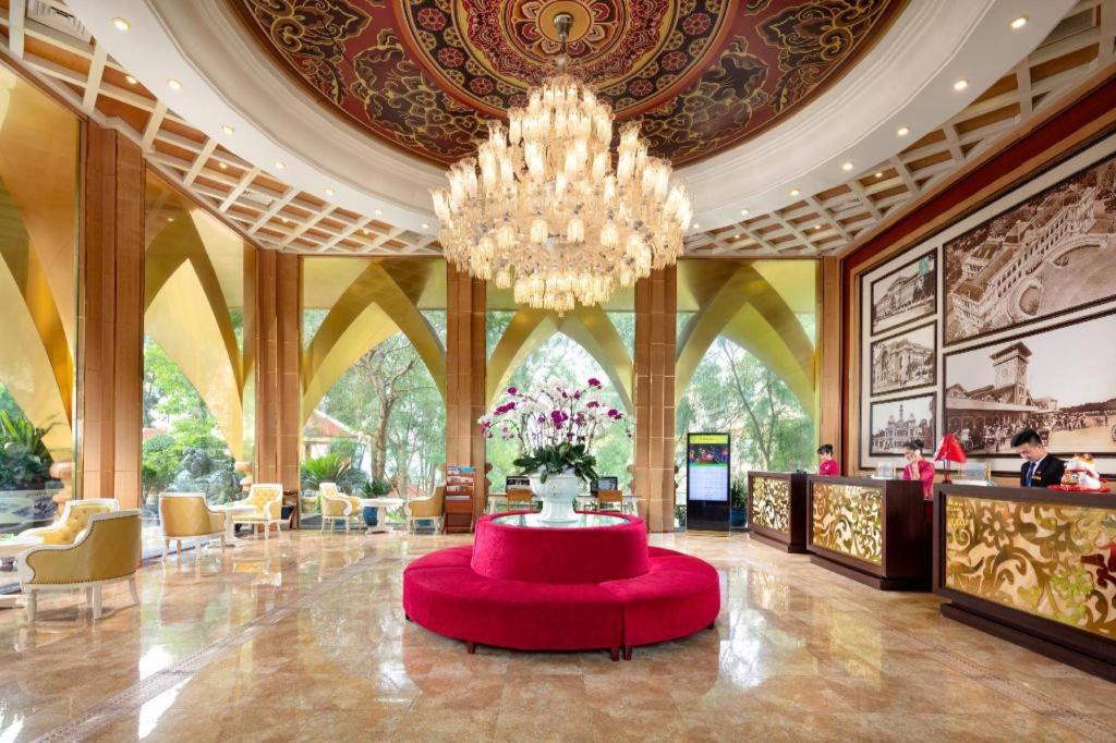eine große Lobby mit einem großen Kronleuchter und einem roten Tisch in der Unterkunft Phoenix Resort Bac Ninh in Ðáp Cầu