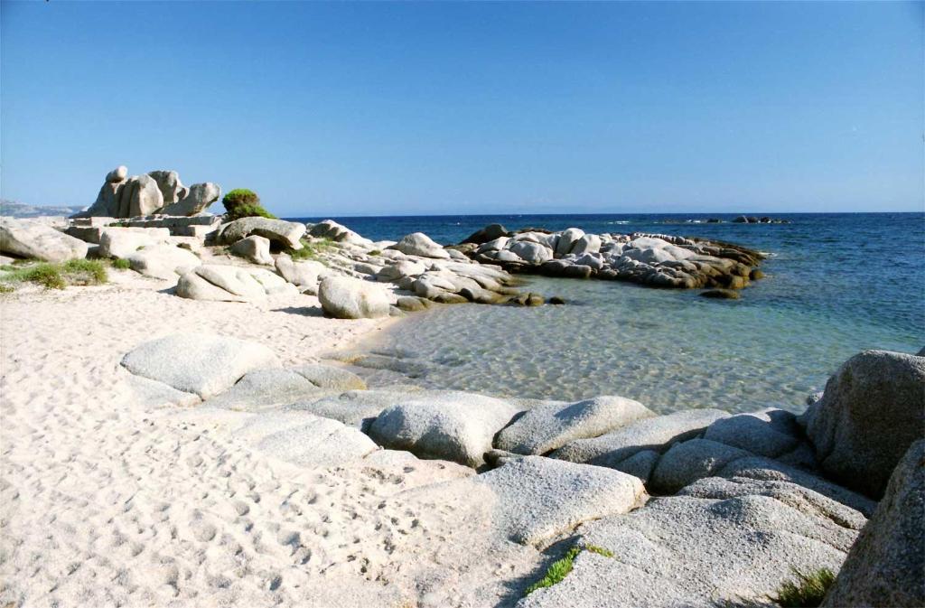 una spiaggia con alcune rocce e acqua e l'oceano di Casa Susini a Pianottoli-Caldarello