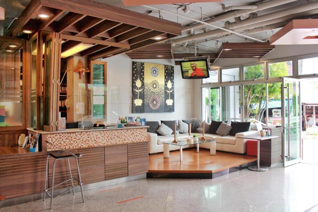 eine Lobby mit Sofas und einem TV in einem Gebäude in der Unterkunft The Finn Hotel in Ban Liap