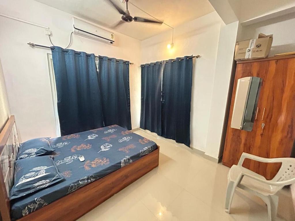 a bedroom with a bed and a chair and a window at Krupasindhu Homestay Ratnagiri in Hatkamba