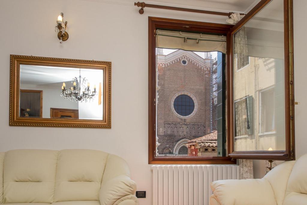 una sala de estar con 2 sofás blancos y un espejo en Casa a San Giovanni Paolo, en Venecia