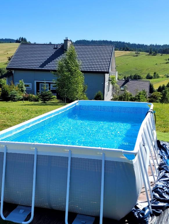 a large swimming pool in front of a house at Tabaszówka in Krynica Zdrój