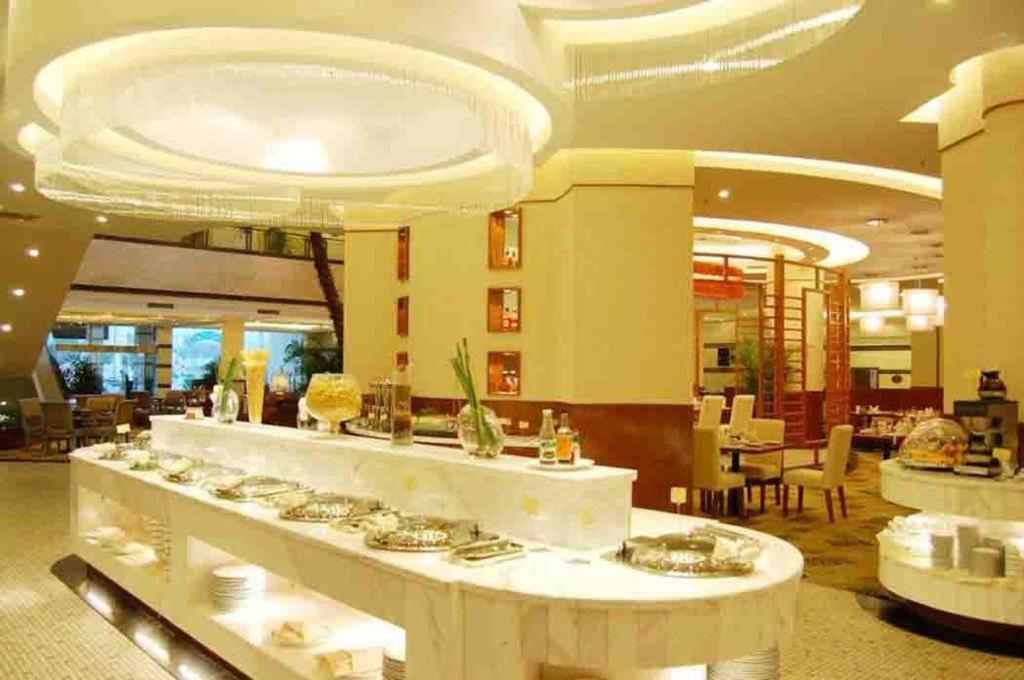 a large lobby with a dining area and a buffet at New Century Hotel Ninghai in Shang-ts'un