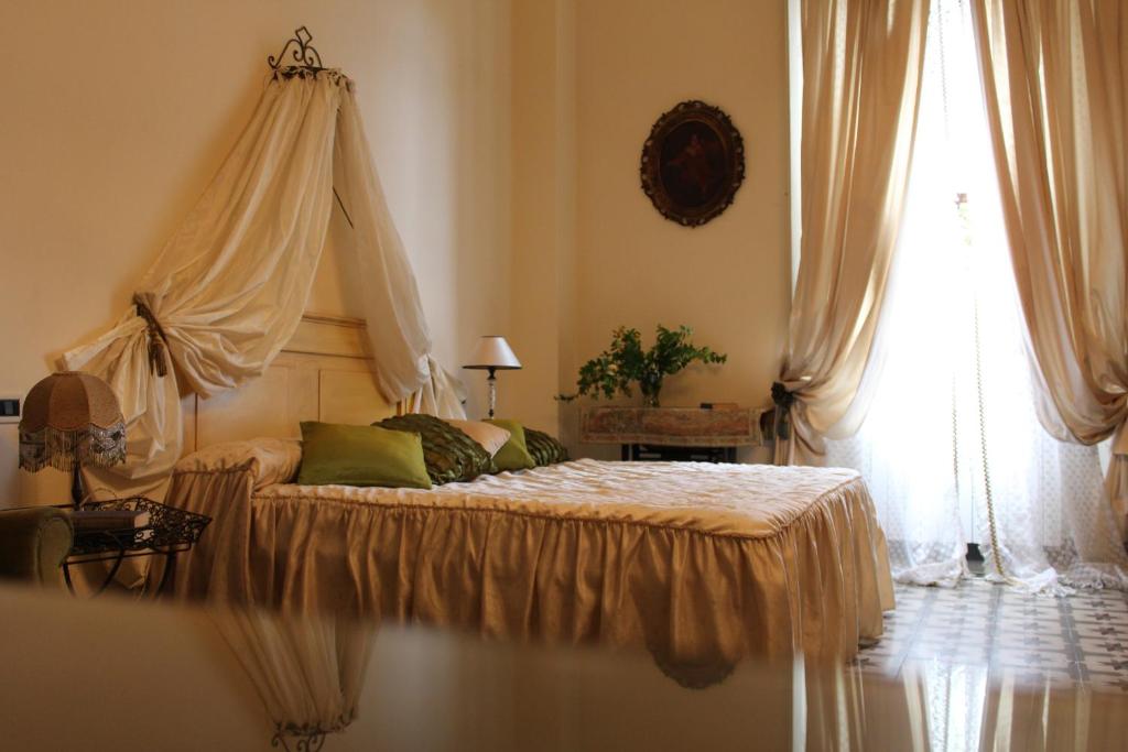 トッレ・デル・ラーゴ・プッチーニにあるCasa Simonettiのベッドルーム1室(天蓋付きベッド1台、窓付)