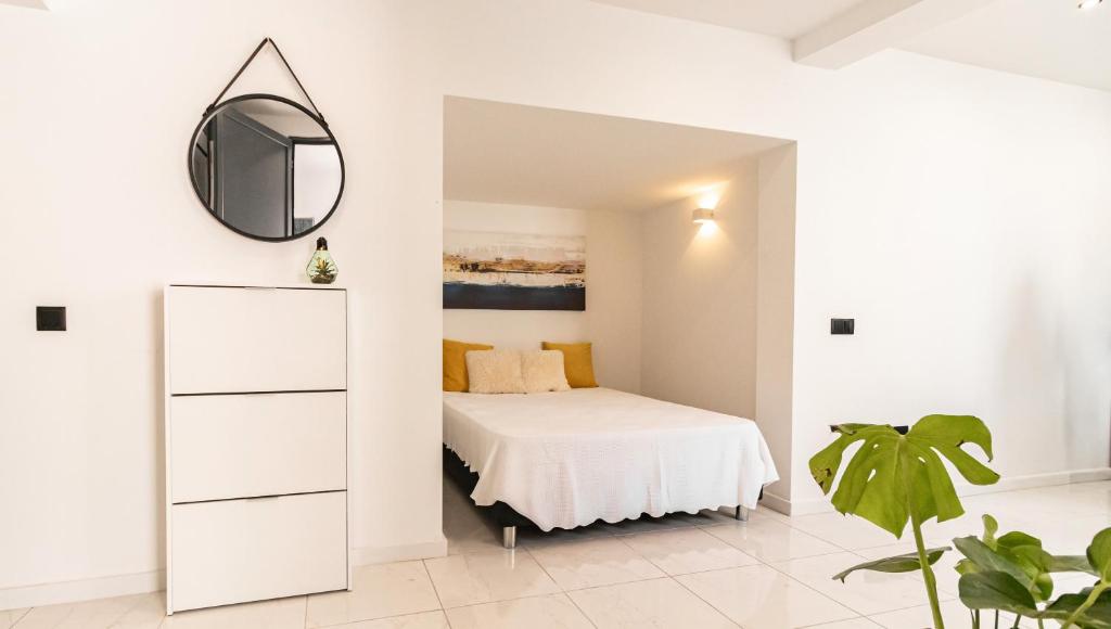a white bedroom with a bed and a mirror at Mi Casa Es Su Casa Nº2 in Albufeira
