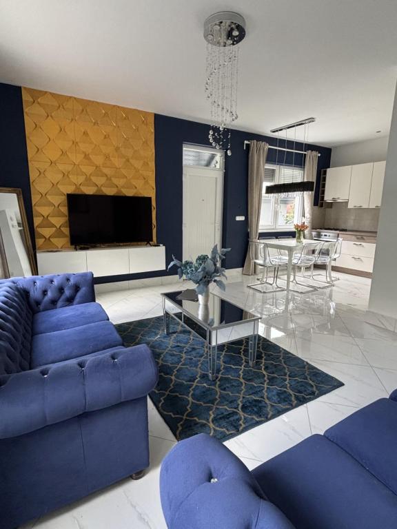 een woonkamer met een blauwe bank en een tafel bij Dorothy 2 in Siófok