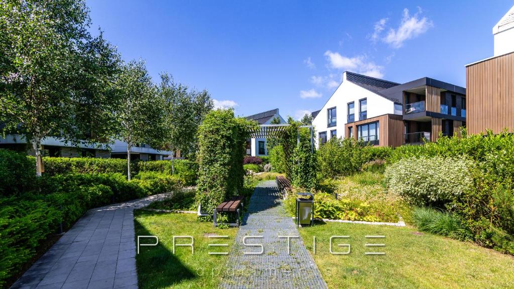 ogród z ławką przed budynkiem w obiekcie Prestige Apartments Botanica w Gdańsku