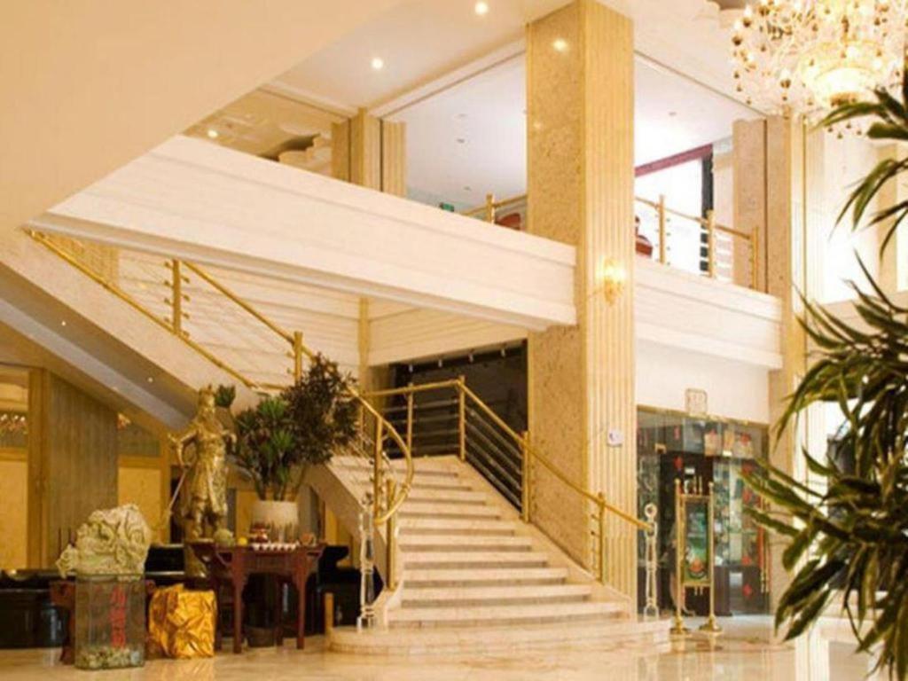 eine Lobby mit einer Treppe in einem Gebäude in der Unterkunft Qingdao Danube International Hotel in Qingdao