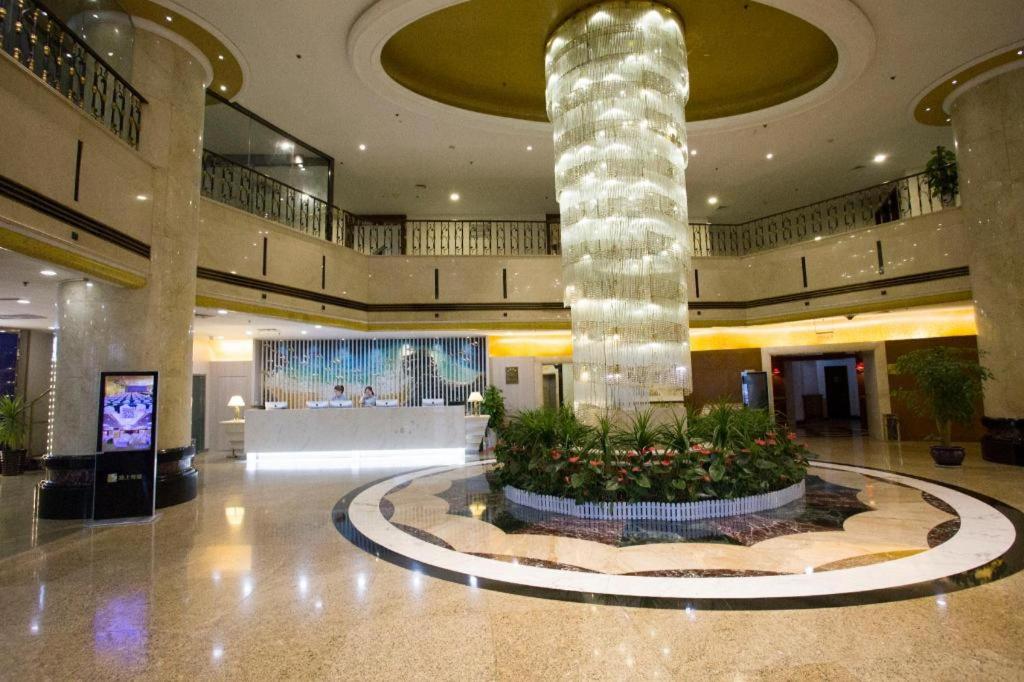 a lobby with a large column in the middle of a building at Dalian Bohai Pearl Hotel in Dalian