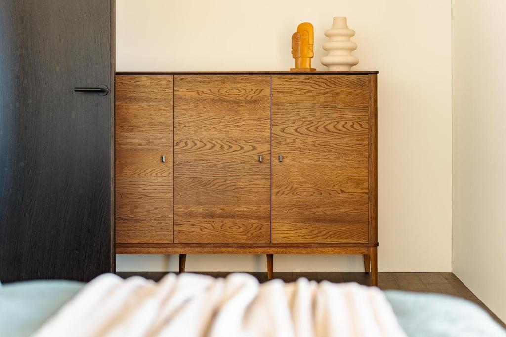 eine hölzerne Kommode in einem Zimmer mit einem Bett in der Unterkunft SVENCELE DUNES Marių g 31-1 in Svenele
