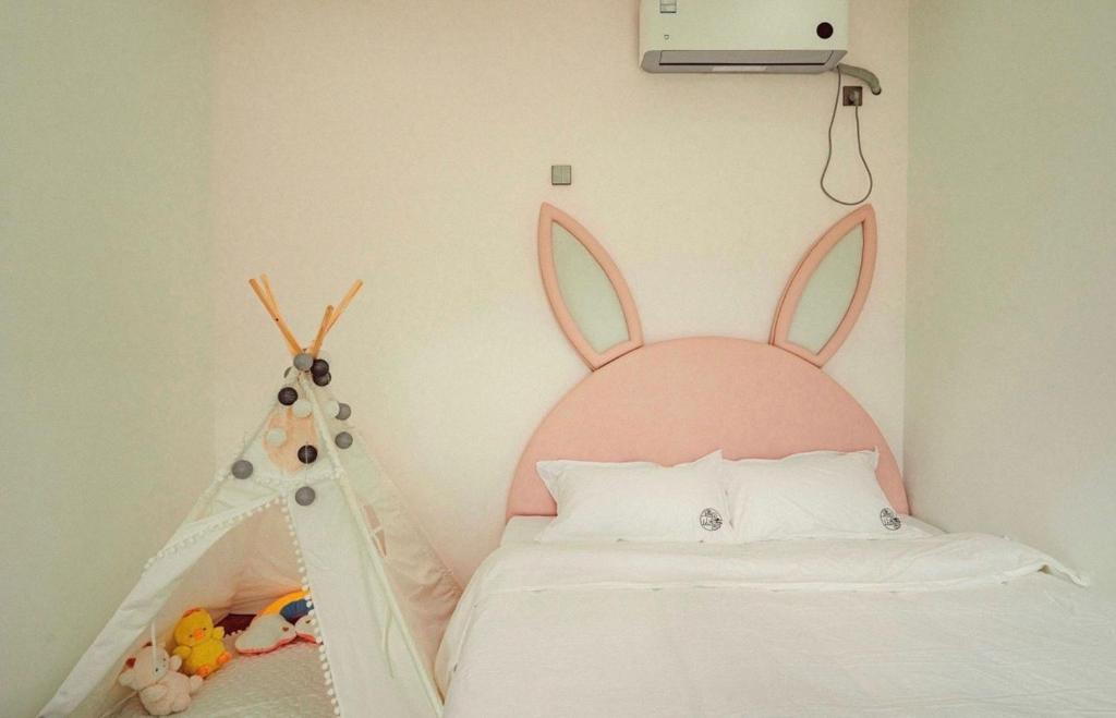 ZhangshanyingBeijing Meet the Mountain Boutique Guesthouse的卧室里有一张床，墙上挂着一个兔子头
