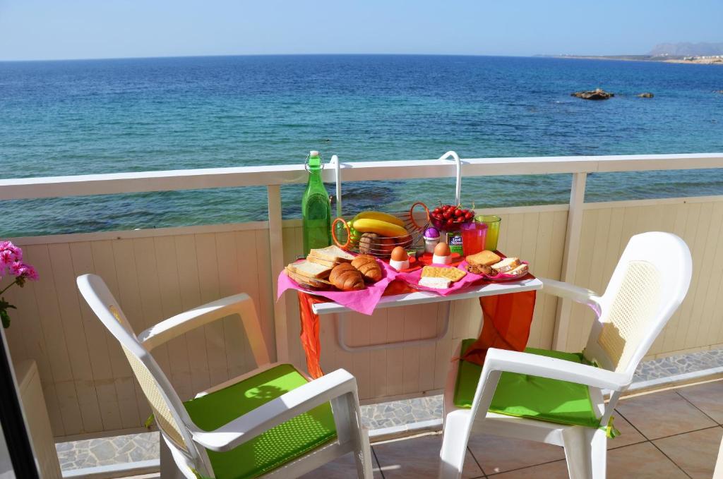 un tavolo con cibo su un balcone con vista sull'oceano di Julies Studios a Chania