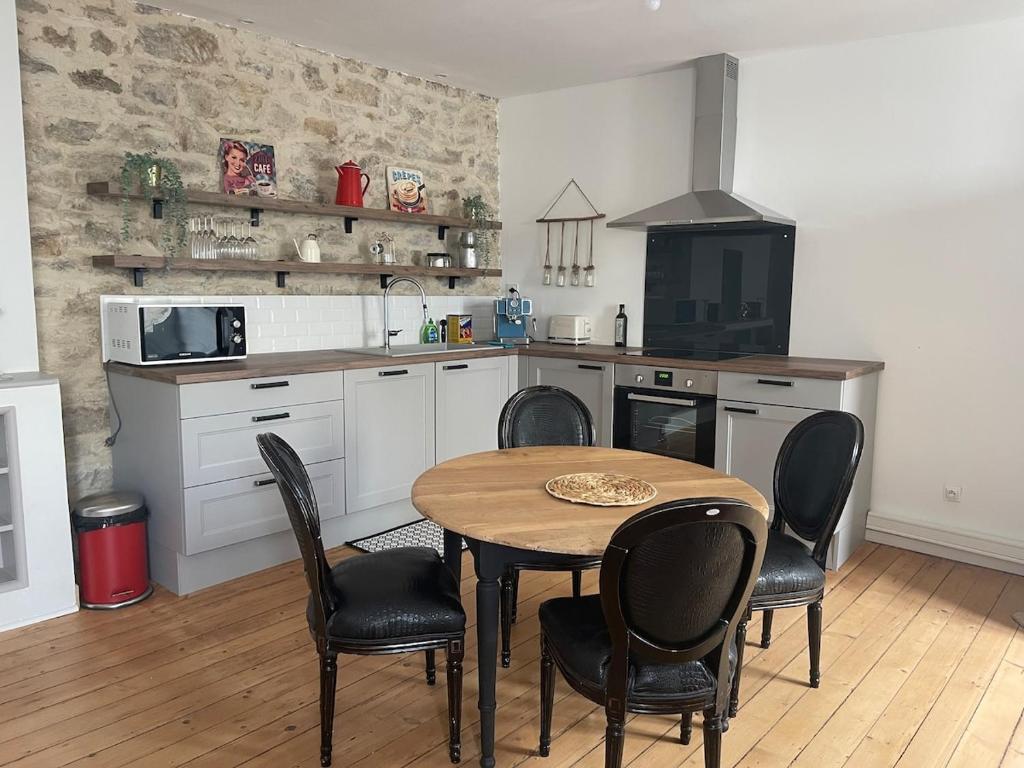 Una cocina con una mesa y sillas en una cocina. en L'ideal, en Vannes