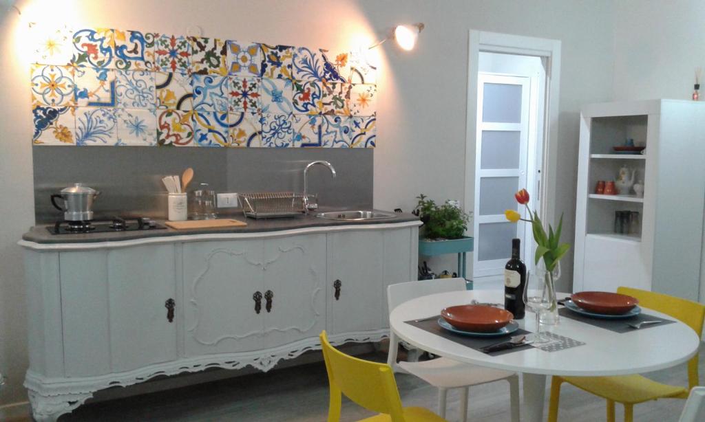 una cucina con lavandino e tavolo con sedie gialle di Home Sweet Home a Palermo