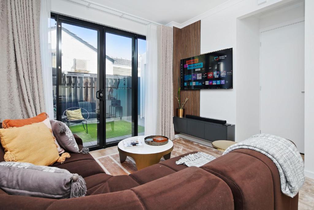 a living room with a couch and a tv at Quiet Suburban Escape Near Shops & Dining in Gepps Cross