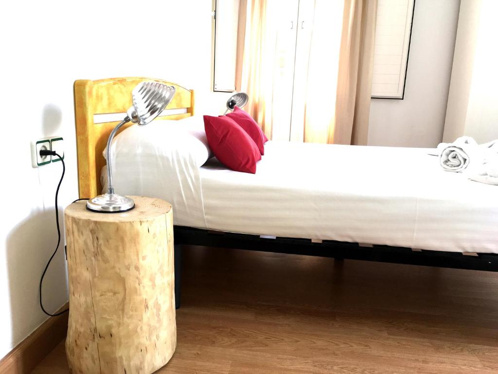 a bedroom with a bed with a lamp on a stump at Hostal la Palmera in Barcelona