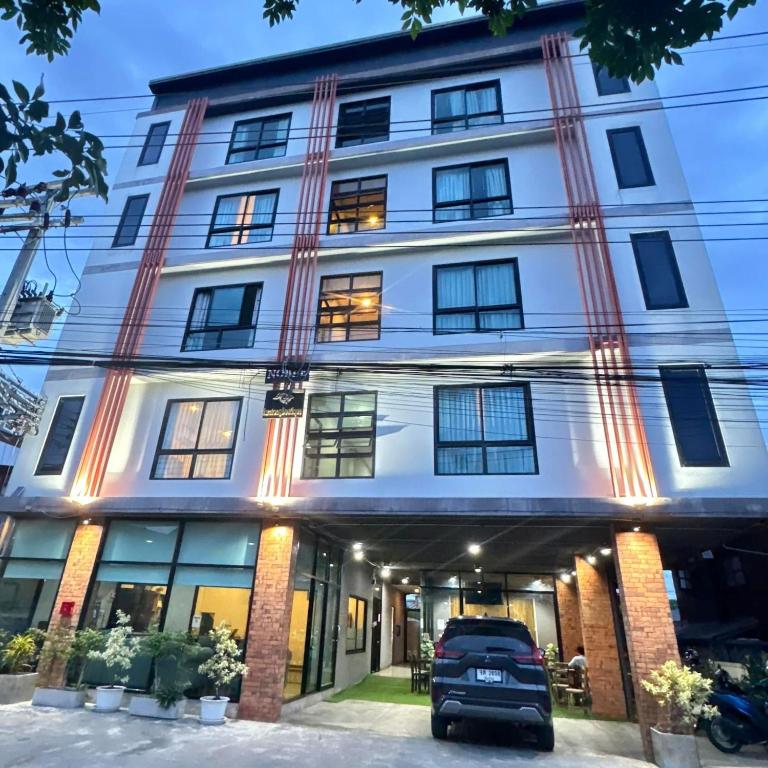 a building with a car parked in front of it at Noble Boutique Hotel Chiang Mai By J&S Property in Chiang Mai