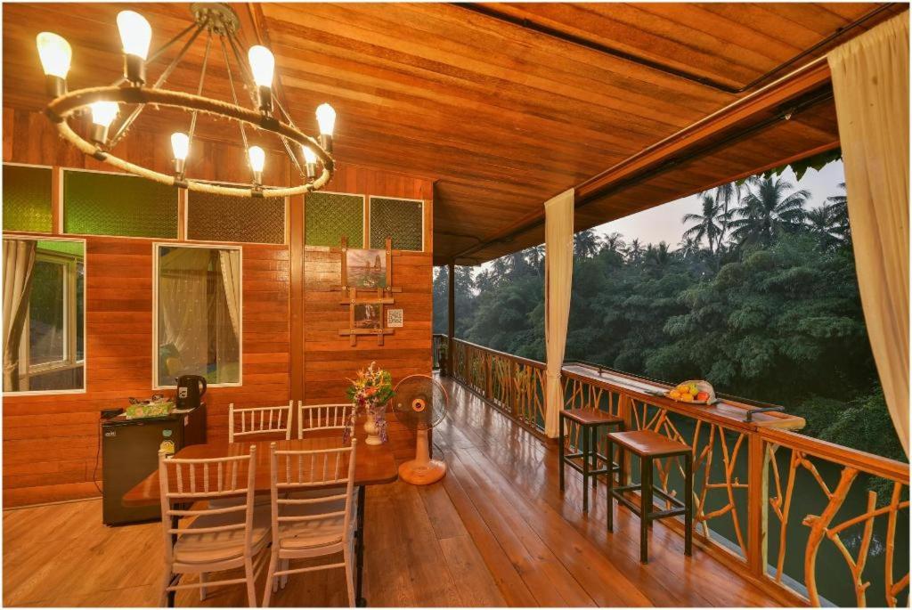 a room with a balcony with chairs and a chandelier at Tamsabai Resort in Ban Na Nian