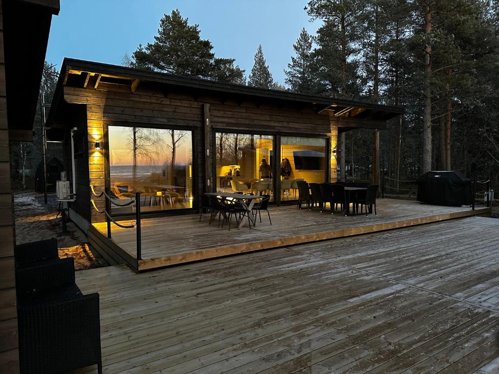 a large wooden deck with tables and chairs on it at Villa Terwaluoto in Oulu