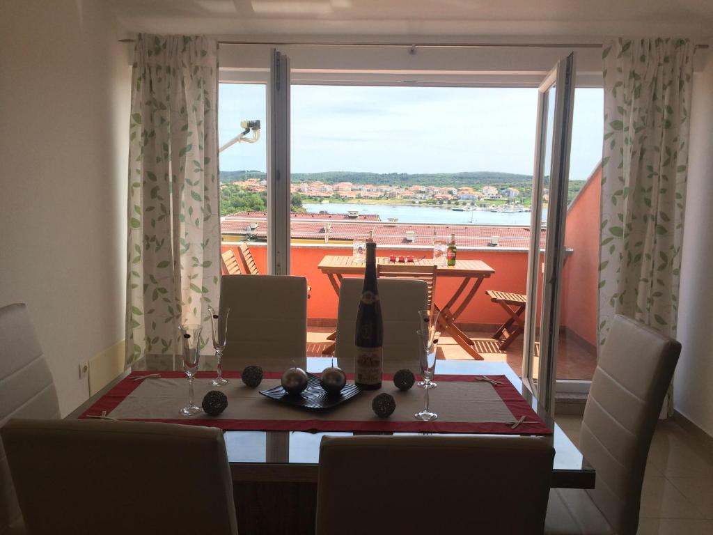 a dining room table with a view of a balcony at Apartments Lucefinka in Banjole