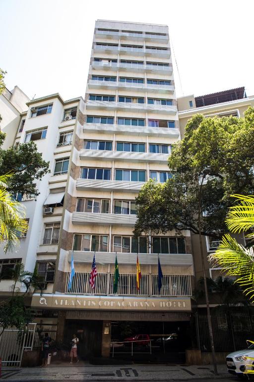 a tall building with flags in front of it at Atlantis Copacabana Hotel in Rio de Janeiro