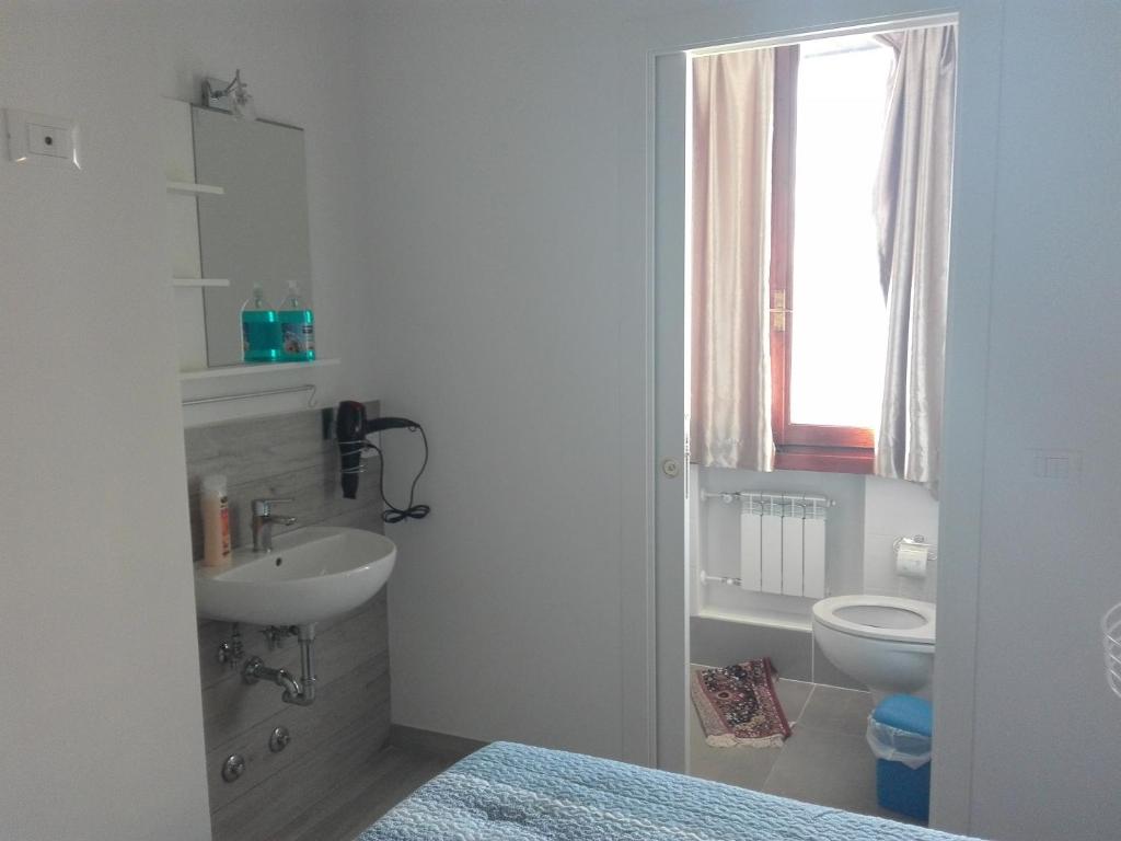 bagno bianco con lavandino e servizi igienici di Nancy House a Firenze