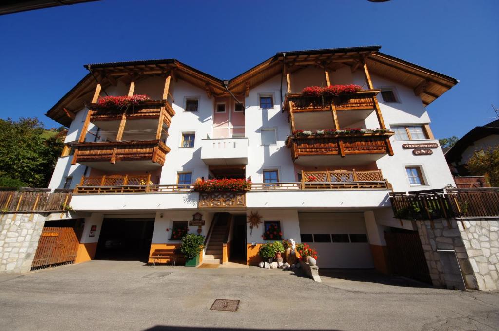um grande edifício com varandas e flores em Gasthof La Pli Apartments em San Vigilio Di Marebbe