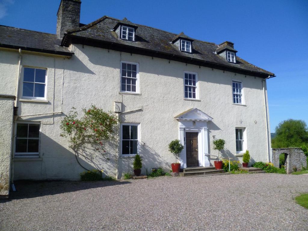 Uma casa branca com uma entrada à frente. em Aberllynfi Riverside Guest House em Glasbury