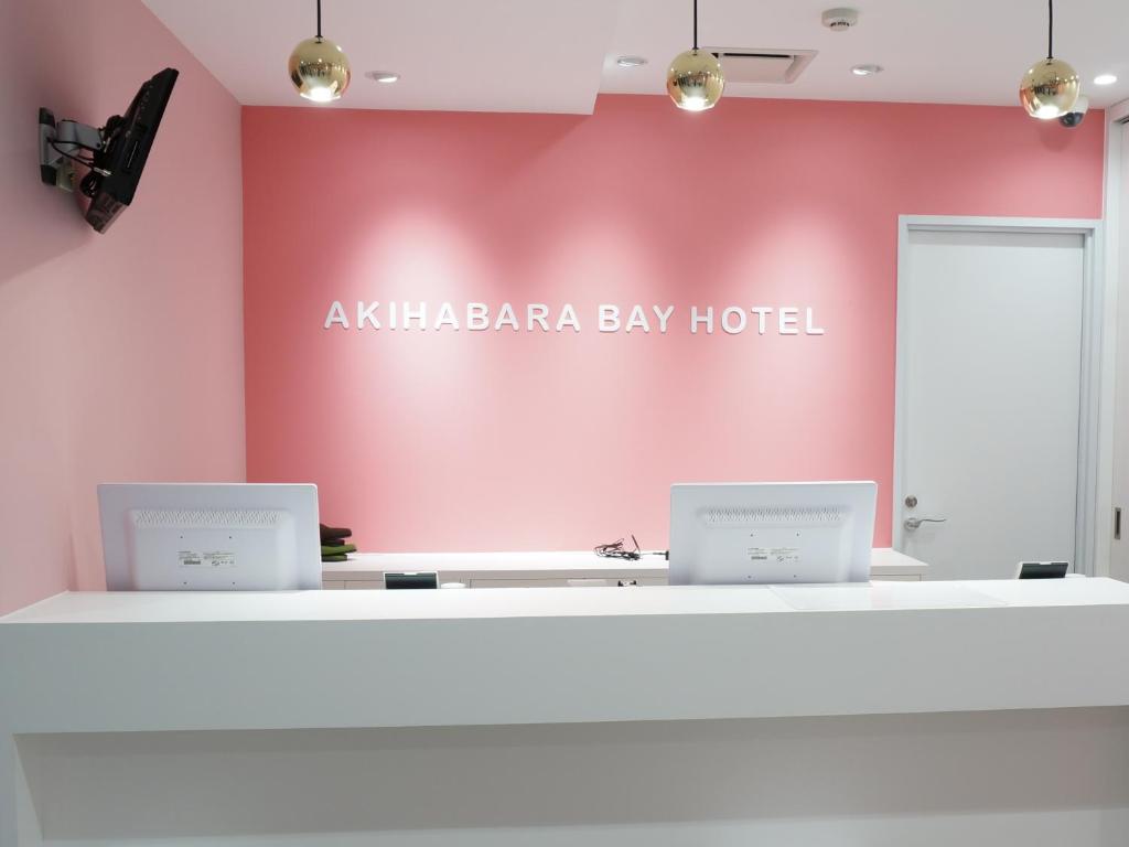 uma sala rosa com dois computadores no balcão em Akihabara Bay Hotel (Female Only) em Tóquio
