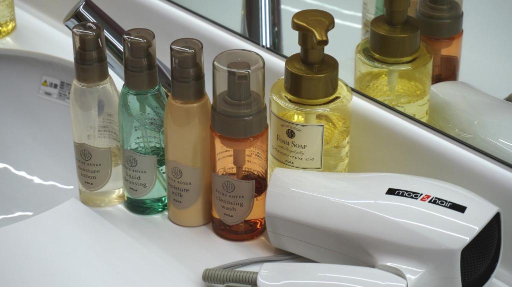 a counter with a bunch of bottles of oils at Akihabara Bay Hotel (Female Only) in Tokyo