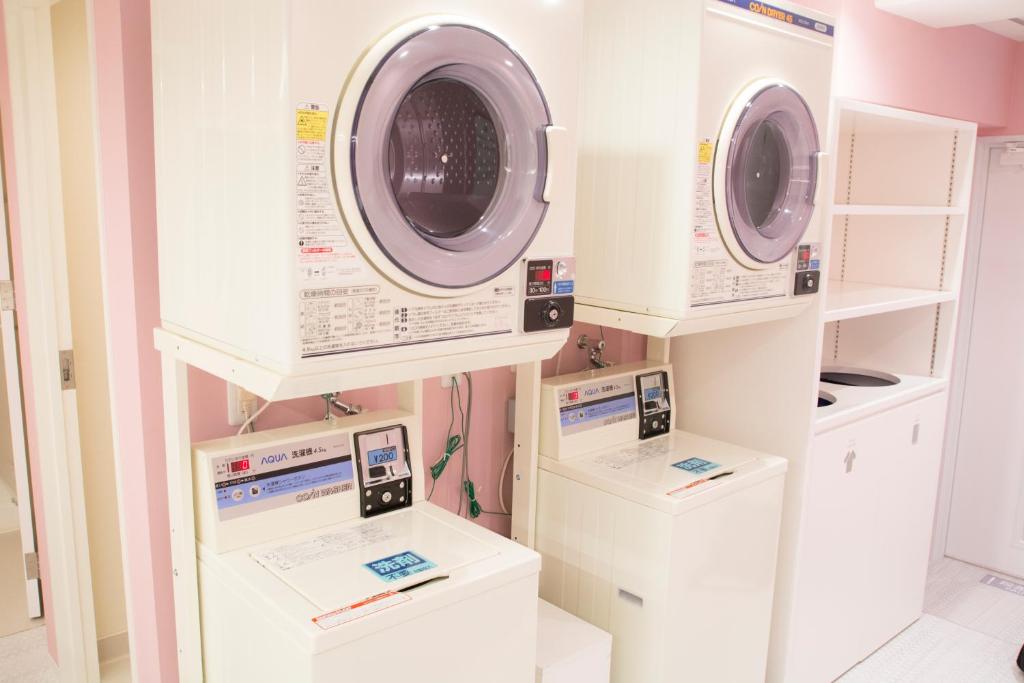 a laundry room with three washing machines on display at Akihabara Bay Hotel (Female Only) in Tokyo
