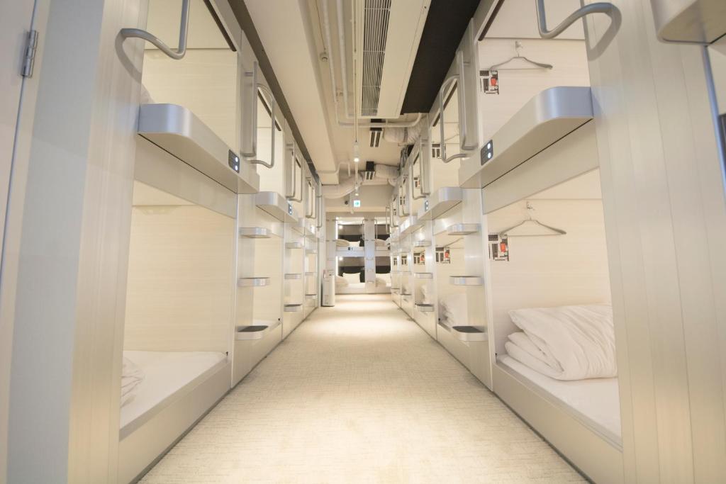 a hallway with white bunk beds in a room at Akihabara Bay Hotel (Female Only) in Tokyo