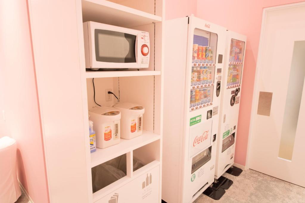 a kitchen with a microwave and a refrigerator at Akihabara Bay Hotel (Female Only) in Tokyo