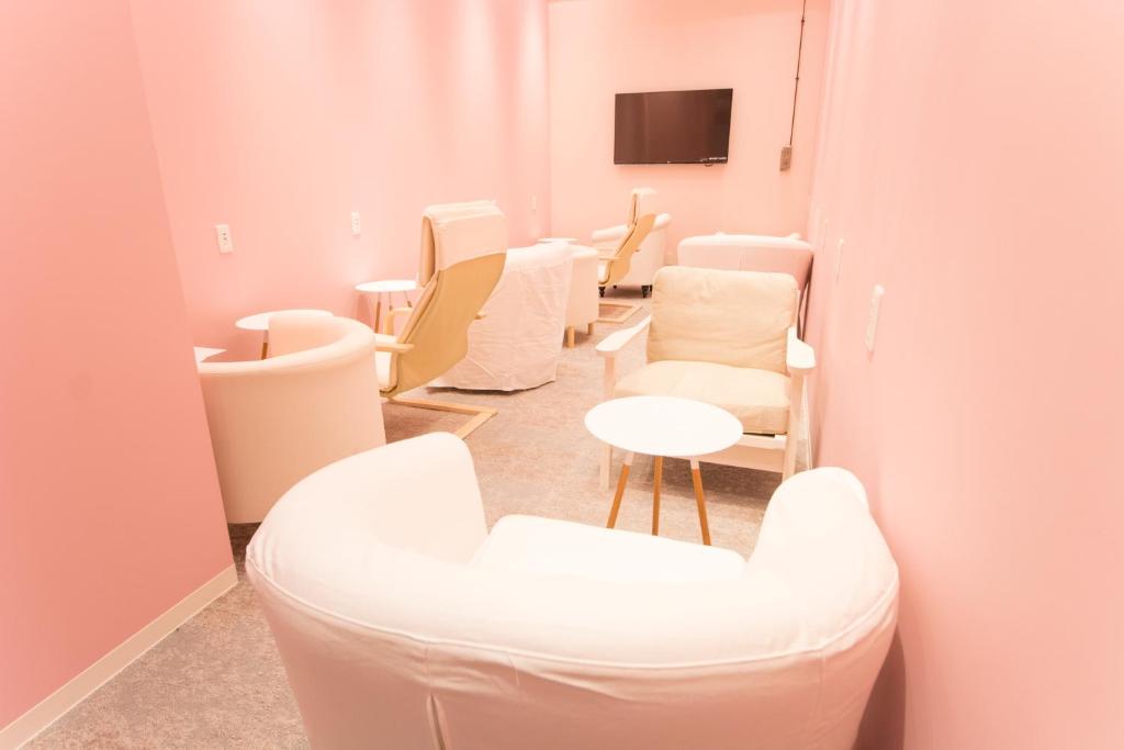 a waiting room with white chairs and a table at Akihabara Bay Hotel (Female Only) in Tokyo