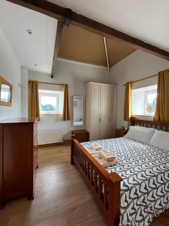 una camera con un grande letto e due finestre di Town center duplex with lift a Clonakilty