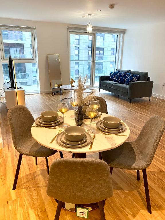 een woonkamer met een tafel met stoelen en een bank bij Luxurious 2 Bedroom - Water View and Parking in Manchester