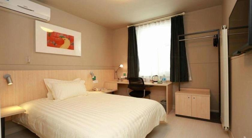 ein Schlafzimmer mit Bett, Schreibtisch und Fenster in der Unterkunft Jinjiang Inn Hotel Tianjin Xinkai Road Branch in Tianjin