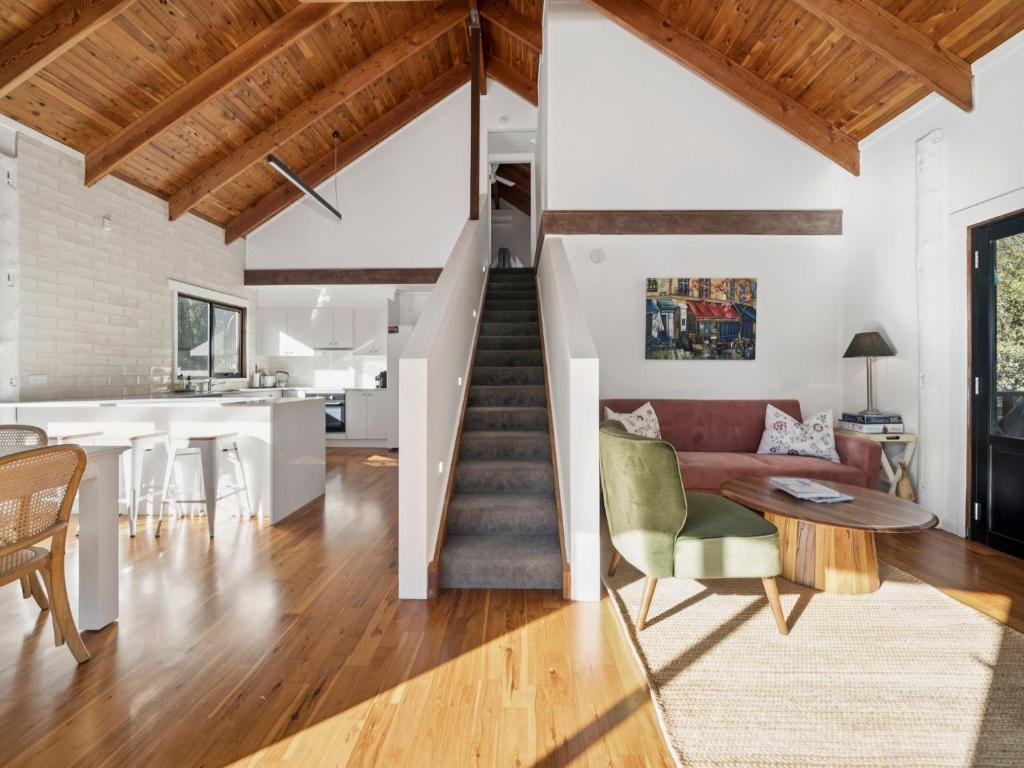 un soggiorno con un divano e un tavolo di Treetop Escape a Katoomba