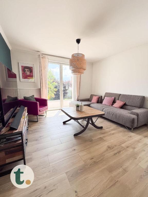 un salon avec un canapé et une table dans l'établissement Tranquiloue - Maison Cosy à 15min du PuyduFou, aux Herbiers