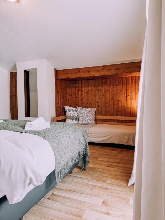 ein Schlafzimmer mit zwei Betten und Holzwänden in der Unterkunft Das Luis in Altenmarkt im Pongau