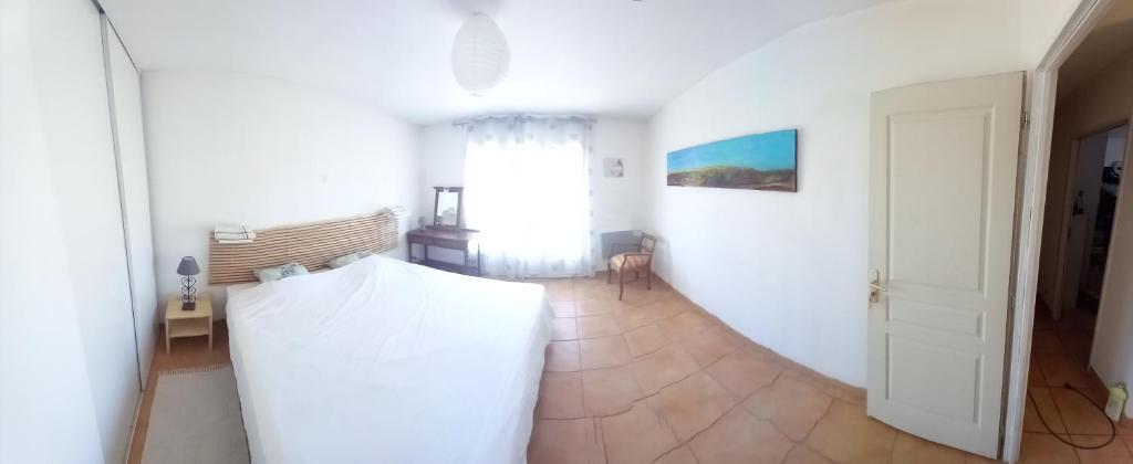 - un salon avec un mur blanc et une porte dans l'établissement CHAMBRE ALOEVERA, à Saint-Christol