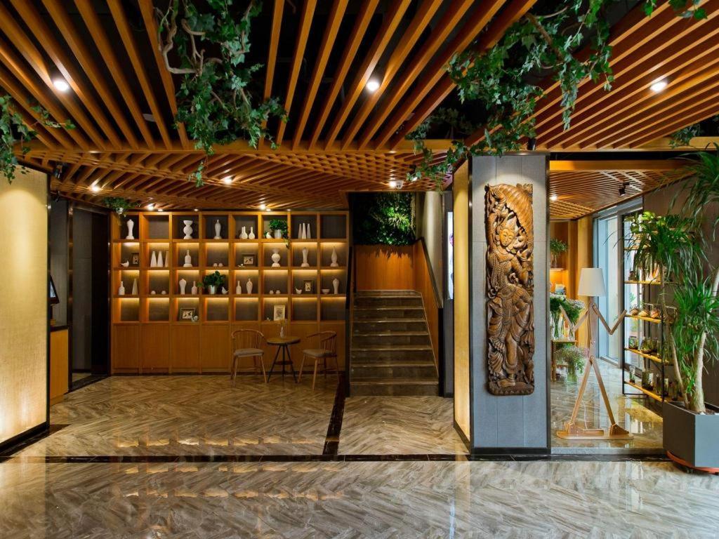 a lobby with a staircase and a table and chairs at Musang Smart Hotel Changzhou in Changzhou