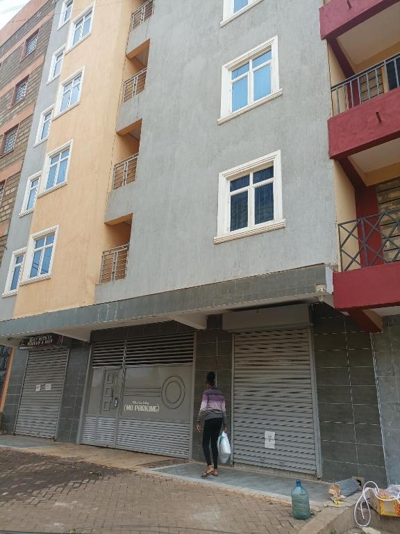 a woman standing in front of a building at BNB Makutano Meru in Meru