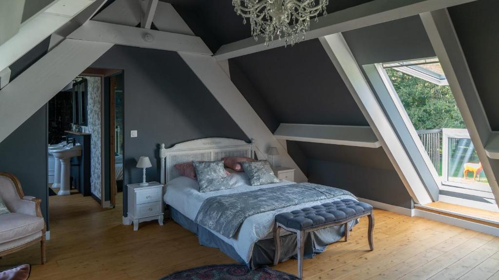 a bedroom with a bed and a large window at Domaine du Turbais in Luynes