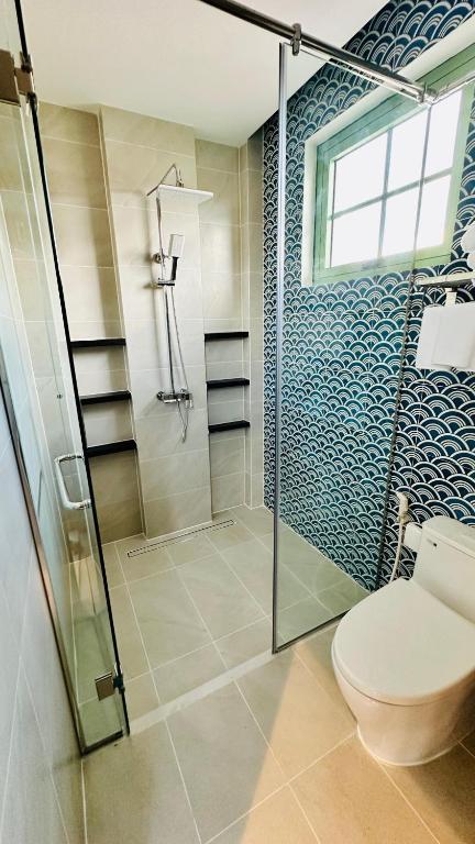 a bathroom with a toilet and a glass shower at Вилла на Bai Khem in Phu Quoc