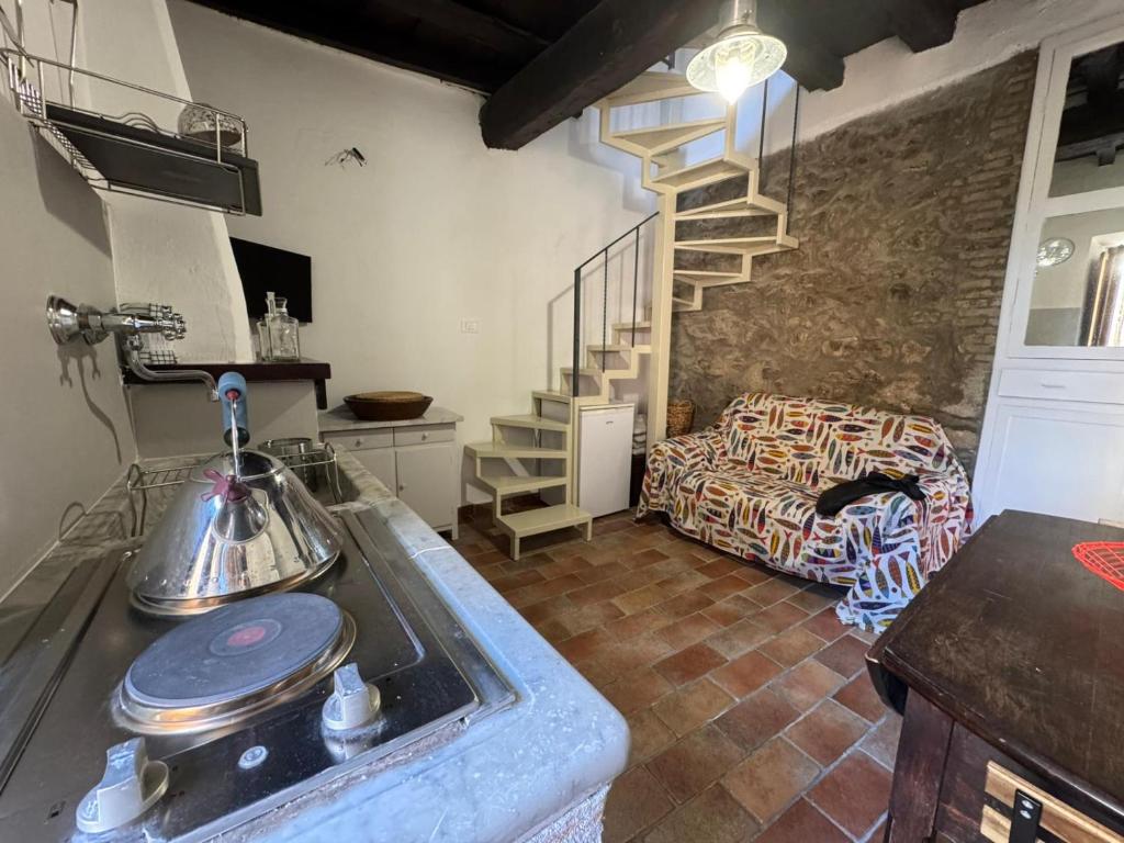 a kitchen with a sink and a spiral staircase at Romantic House in Trevignano Romano