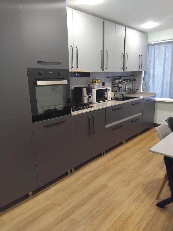 a kitchen with white cabinets and stainless steel appliances at Lili's Flat in Angisa