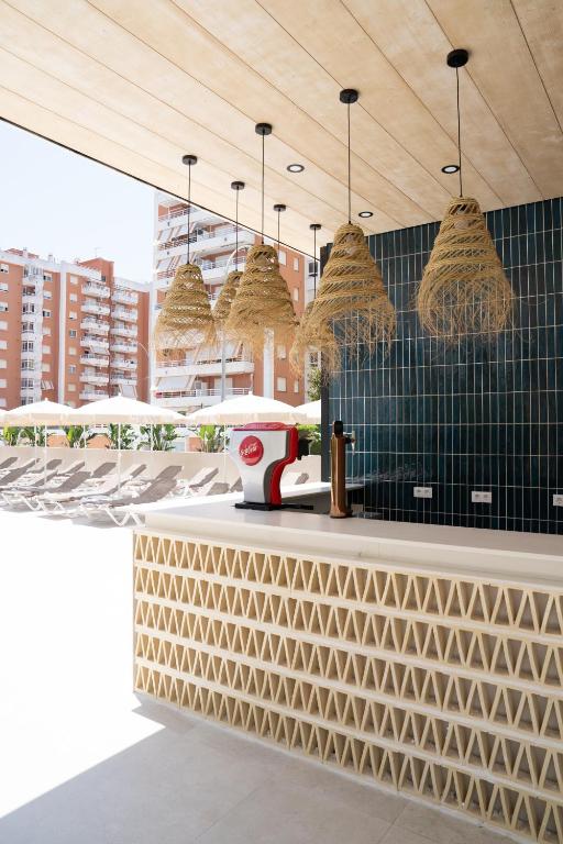 a restaurant with a counter with baskets on the wall at Hotel RH Arena - Todo Incluido in Gandía